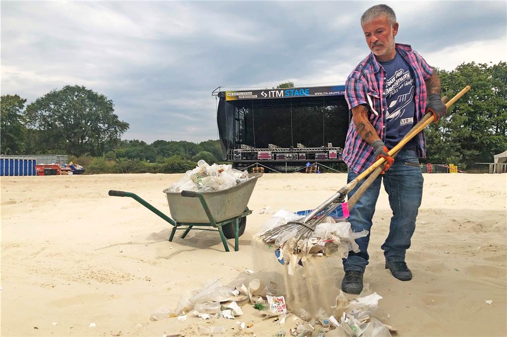 Kehraus beim Dodgeball: Ballenpresse sammelt Plastikbecher wie Heu Plastikreste werden per Handarbeit auf dem Beach aufgesammelt, damit der Sand für Bauzwecke verwertet werden kann.