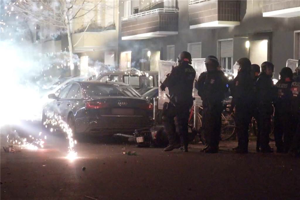 Wachleiter Schulte zur Gewalt gegen Feuerwehrleute: „Hemmschwelle sinkt“ Polizeibeamte in Berlin stehen hinter explodierendem Feuerwerk.