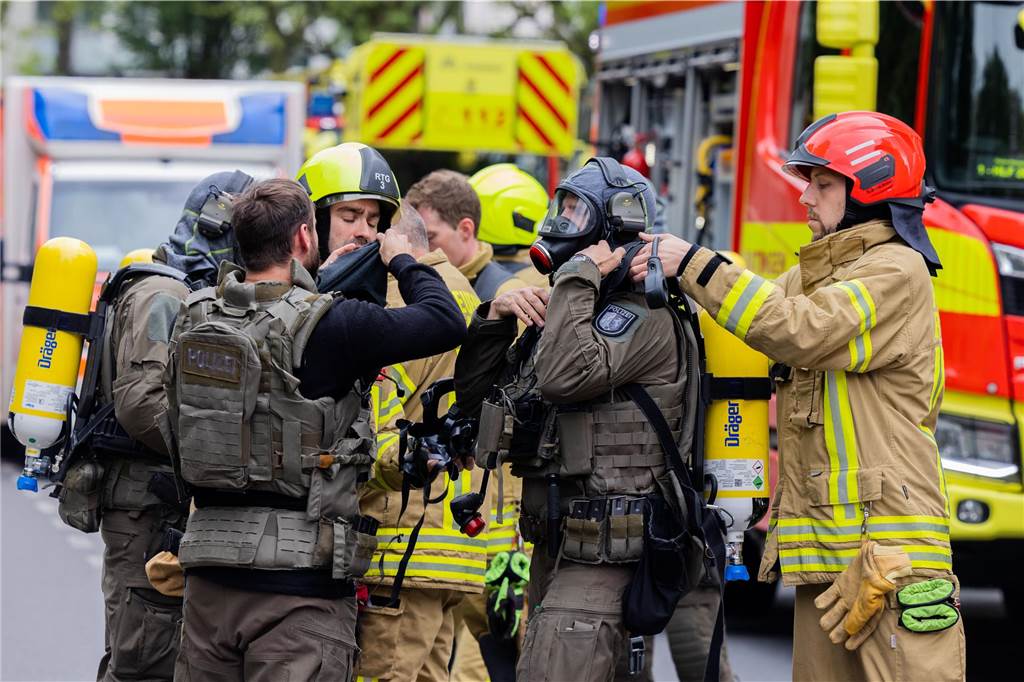 Polizeibeamte mit Gasmasken und Feuerwehrleute stehen vor einem Hochhaus. Bei einer Explosion in einem Hochhaus in Ratingen am Donnerstagvormittag wurden mehrere Menschen verletzt - darunter auch Polizisten und Einsatzkräfte der Feuerwehr. Das erfuhr die Deutsche Presse-Agentur aus Polizeikreisen.