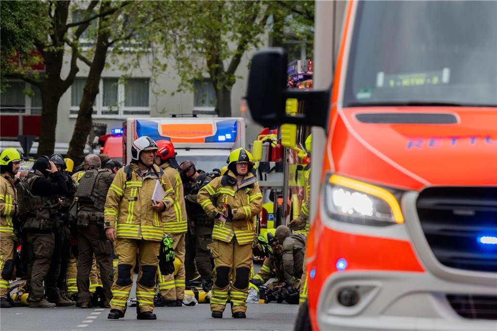 Polizeibeamte mit Gasmasken und Feuerwehrleute stehen vor einem Hochhaus. Bei einer Explosion in einem Hochhaus in Ratingen am Donnerstagvormittag wurden mehrere Menschen verletzt - darunter auch Polizisten und Einsatzkräfte der Feuerwehr. Das erfuhr die Deutsche Presse-Agentur aus Polizeikreisen.