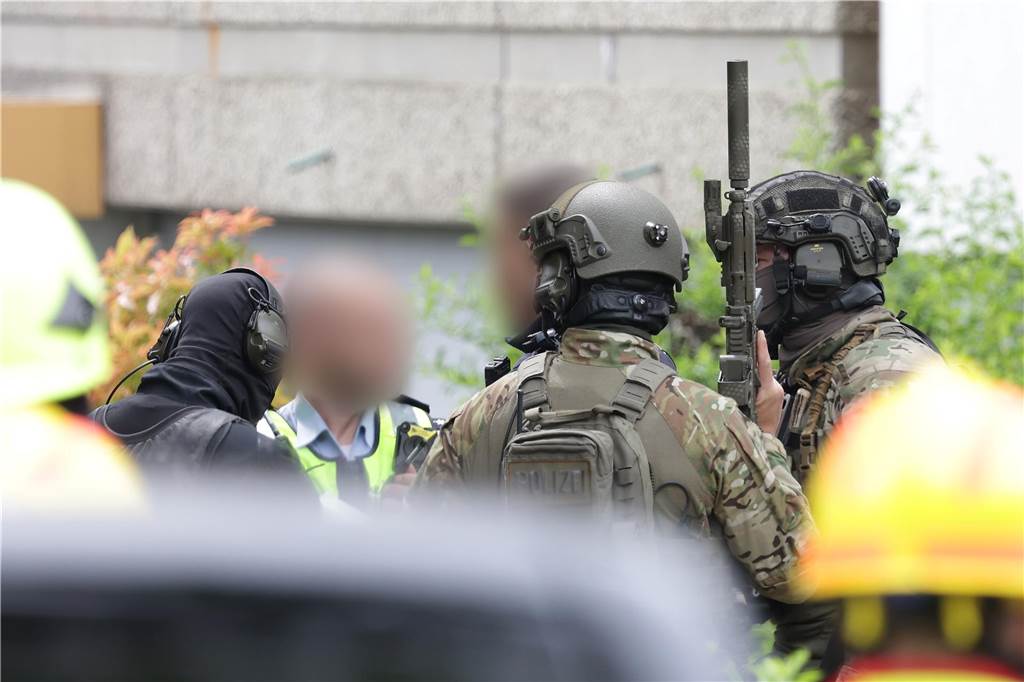 Polizeibeamte mit Spezialausrüstung stehen vor einem Hochhaus. Bei einer Explosion in einem Hochhaus in Ratingen am Donnerstagvormittag wurden mehrere Menschen verletzt - darunter auch Polizisten und Einsatzkräfte der Feuerwehr. Das erfuhr die Deutsche Presse-Agentur aus Polizeikreisen.