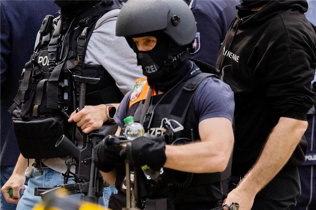 Polizeibeamte mit Spezialausrüstung stehen vor einem Hochhaus. Bei einer Explosion in einem Hochhaus in Ratingen am Donnerstagvormittag wurden mehrere Menschen verletzt - darunter auch Polizisten und Einsatzkräfte der Feuerwehr. Das erfuhr die Deutsche Presse-Agentur aus Polizeikreisen.