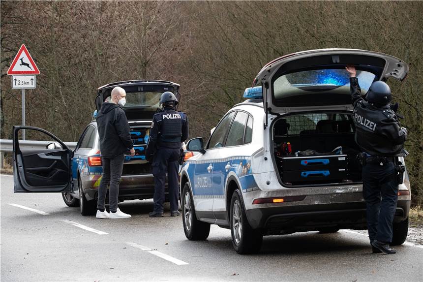 Tödliche Schüsse auf Polizisten: Zwei Verdächtige festgenommen Polizeibeamte stehen an einer Absperrung an der Kreisstraße 22, rund einen Kilometer von dem Tatort entfernt, an dem zwei Polizeibeamte durch Schüsse getötet wurden. Die tödlichen Schüsse fielen nach Polizei-Angaben bei einer routinemäßigen Verkehrskontrolle.