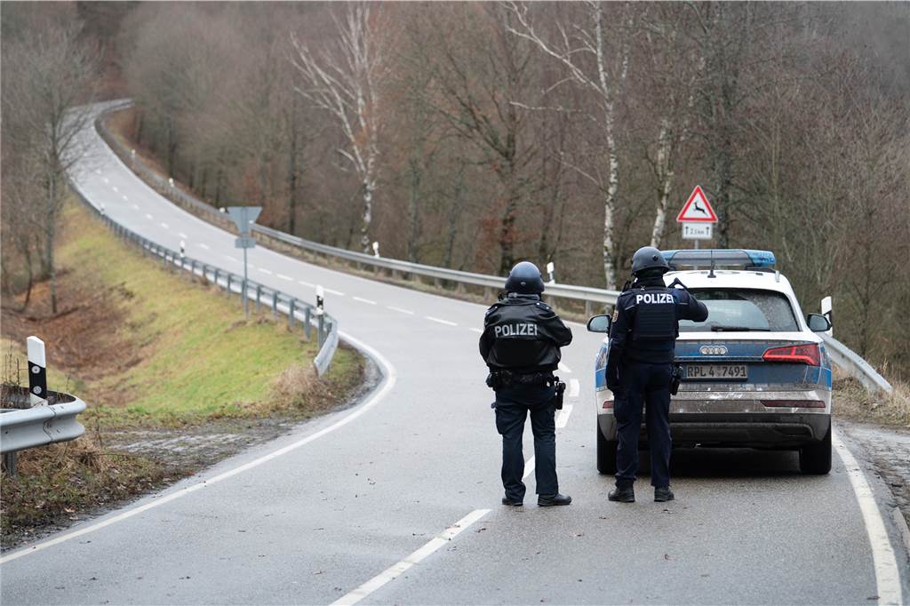 Solidarität und blinder Hass: das komplizierte Verhältnis der Deutschen zu ihrer Polizei Polizeibeamte stehen an einer Absperrung an der Kreisstraße 22 rund einen Kilometer von dem Tatort an dem zwei Polizeibeamte durch Schüsse getötet wurden.
