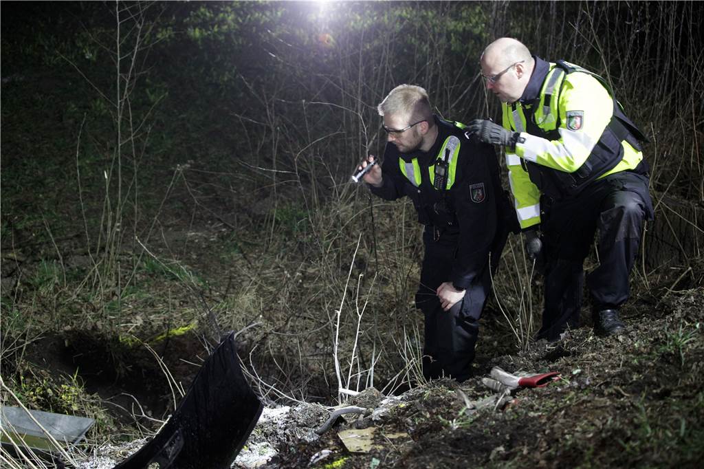 Unfall zwischen Lünen und Dortmund: Kran hob am Abend das Autowrack Polizisten des Unfallaufnahme-Teams der Polizei Dortmund untersuchen nach der Bergung des Autos noch einmal den Unfallort.