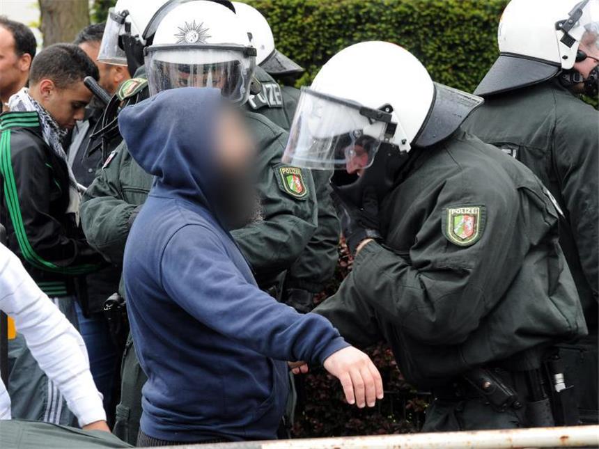 Fremdenfeindliche Gewalttaten um 20 Prozent gestiegen Polizisten durchsuchen einen Demonstranten. Foto: Henning Kaiser/Archiv