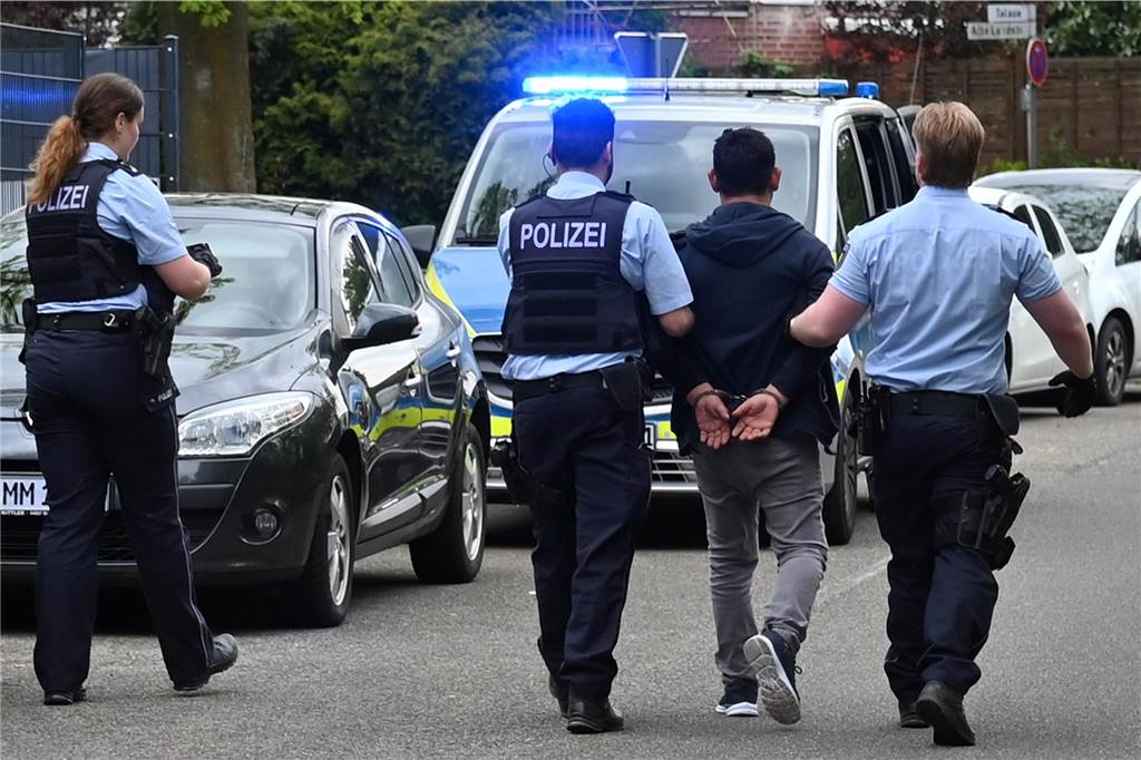 Polizisten führen den Mann ab, der am Samstag in Dorsten seine Frau mit einem Messer attackiert hatte.