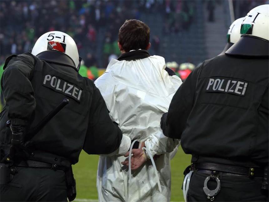 Ermittlungskommission nach Gladbacher Skandal-Spiel Polizisten führen einen Kölner Platzstürmer ab. Foto: Federico Gambarini