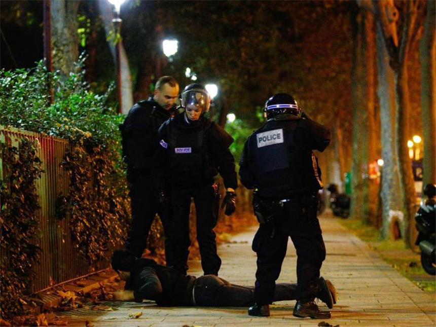 Frankreich steht unter Schock Polizisten haben in der Terrornacht von Paris einen Verdächtigen auf den Boden gezwungen. Foto: Yoan Valat