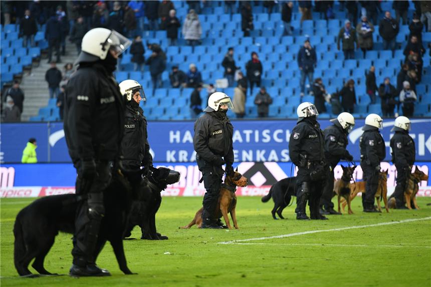 Neun Verletzte - Versuchter Platzsturm in Hamburg Polizisten sichern den Innenraum des Volksparkstadions.