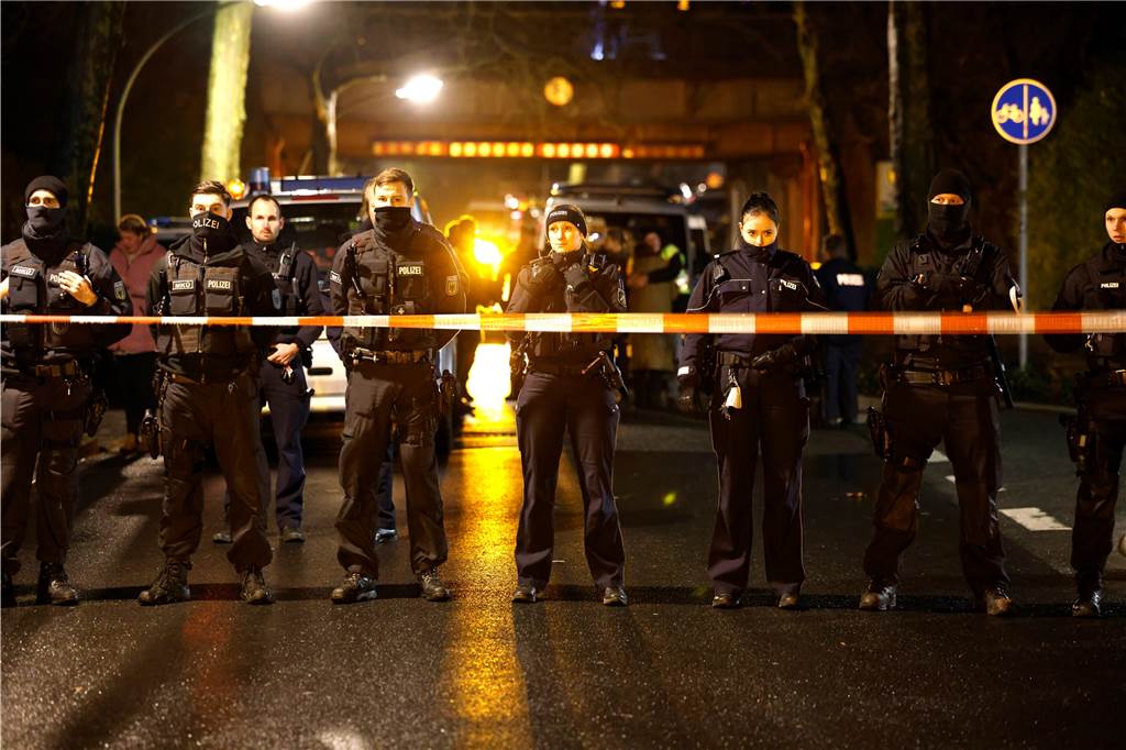 Großeinsatz der Feuerwehr an Gleisen: Einsatzkräfte suchen Personen Uniformierte Polizisten hinter einem Absperrband.
