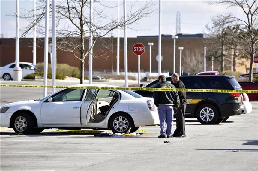 Dreijährige schießt auf schwangere Mutter Polizisten untersuchen den Ort des Dramas auf einem Parkplatz in Merrillville. Foto: Rob Earnshaw/The Times/AP