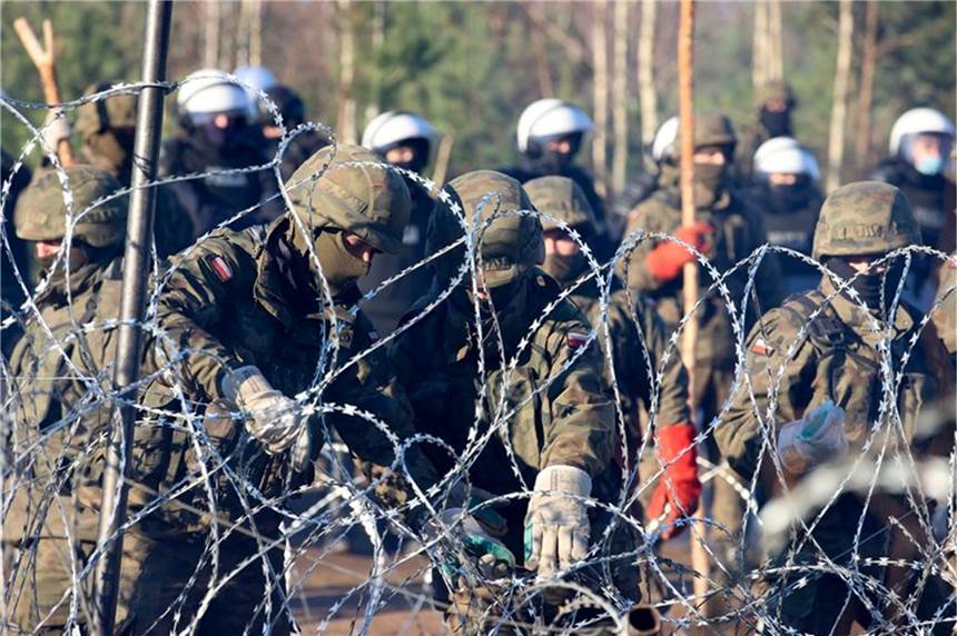 Zäune zerstört: Migranten durchbrechen Grenze von Belarus nach Polen Polnische Polizisten und Grenzschützer stehen in Grodno am Stacheldraht.