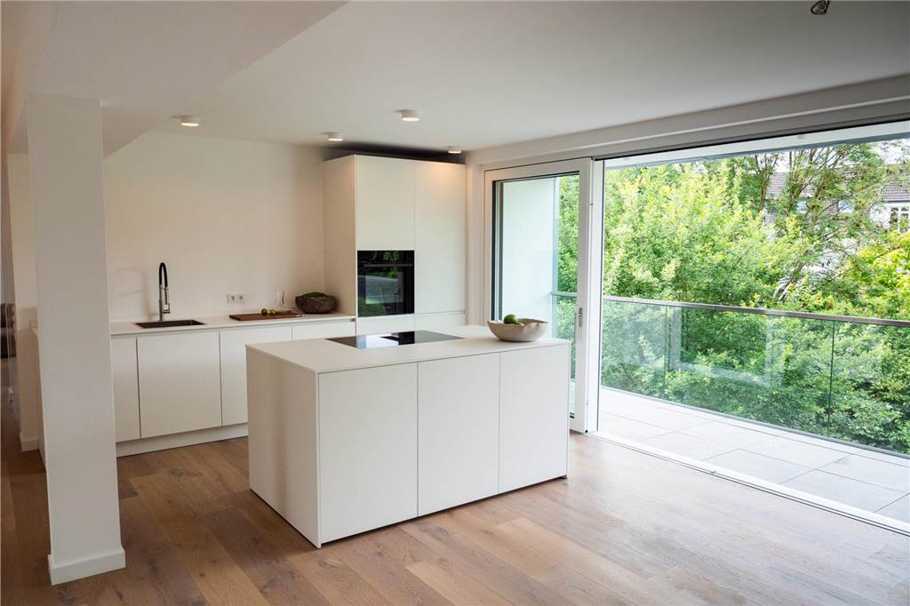 Wohn-Überraschung im Hinterhof: Dieses Loft könnte in Serie gehen Die Küche mit Kochinsel vor dem breiten Balkon.