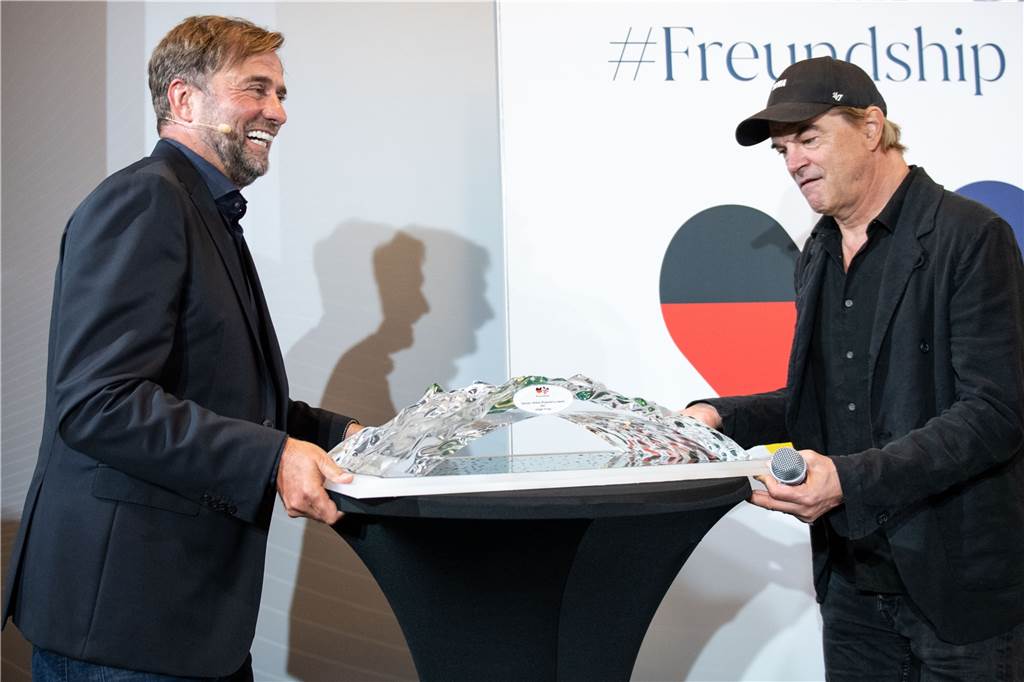 „Dann wird es heller“: Jürgen Klopp und die besondere Rückkehr nach Dortmund Preisträger Jürgen Klopp (l.) und Laudator Campino tragen den Tisch mit dem „German-Britisch#Freundship Award“ in Position.