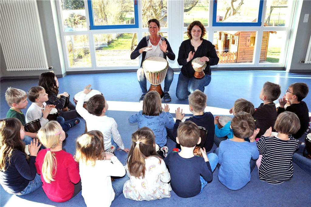 Probe im Kindergarten Heilig Kreuz: Anne Janowski und Melanie Föcker trommeln mit den Kindern zu deutschen und einem afrikanischen Lied. Am Mittwoch bekommen die Familien der Kinder alles Eingeübte bei einem Benefizkonzert im Pfarrheim zu hören. Der Erlös kommt dem Senegal zugute.