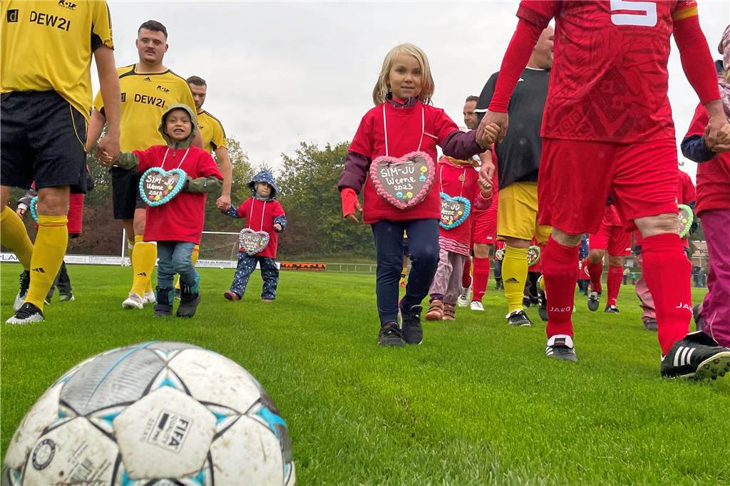 Sim-Jü-Benefizspiel: Hunderte Zuschauer trotzen dem Regen Professionell mit Einlaufkindern an der Hand betraten die Teams der Schausteller (l.) und der Werne Allstars den Rasenplatz im Dahl.
