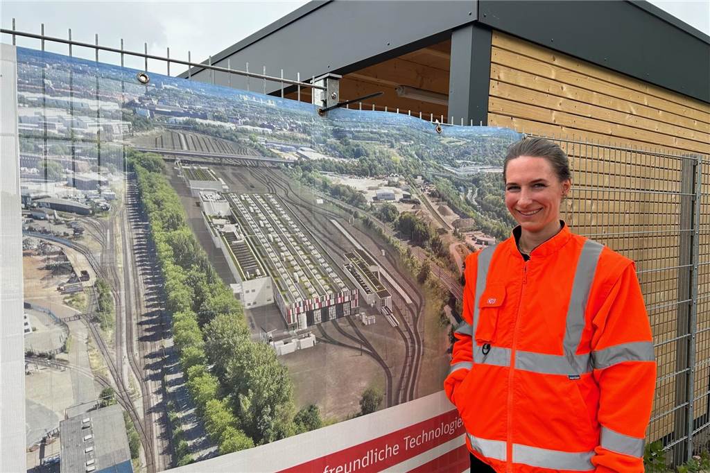 „Leitstand“ für Riesen-Baustelle ist in Betrieb: Vorarbeiten für ICE-Werk Projektleiterin Maria Otte vor dem Transparent, dass das geplante ICE-Werk mit seiner 480 Meter langen Halle zeigt.