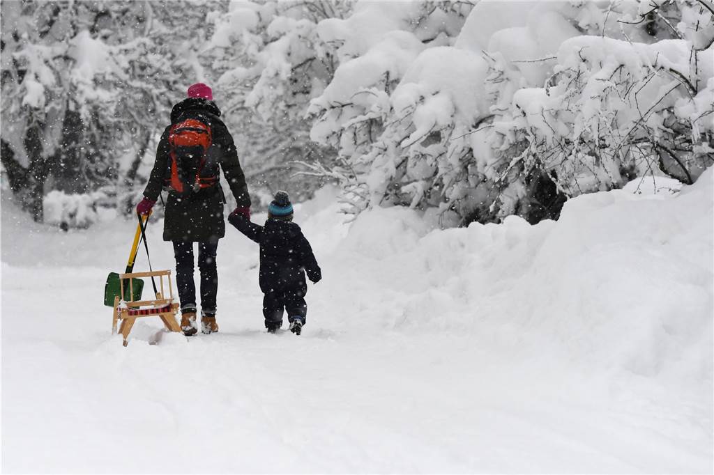 Familien in Not, Experte gibt Rat: Was tun gegen den Corona-Koller? Mutter und Kind mit Schlitten im Schnee