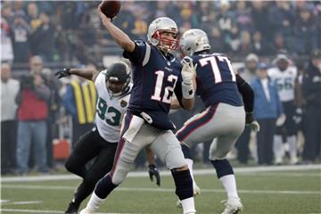 Quaterback Tom Brady (M) von den Patriots wirft unter druck des Defensive End der Jaguars, Calais Campbell, einen Pass. Foto: David J. Phillip