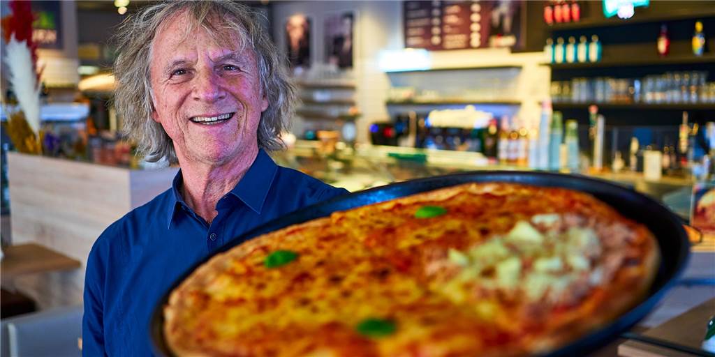 Neues Restaurant: Raimondo Buccolo (64) will den Ostenhellweg aufwerten Restaurant-Inhaber Raimondo Buccolo hält eine große Pizza in die Höhe.
