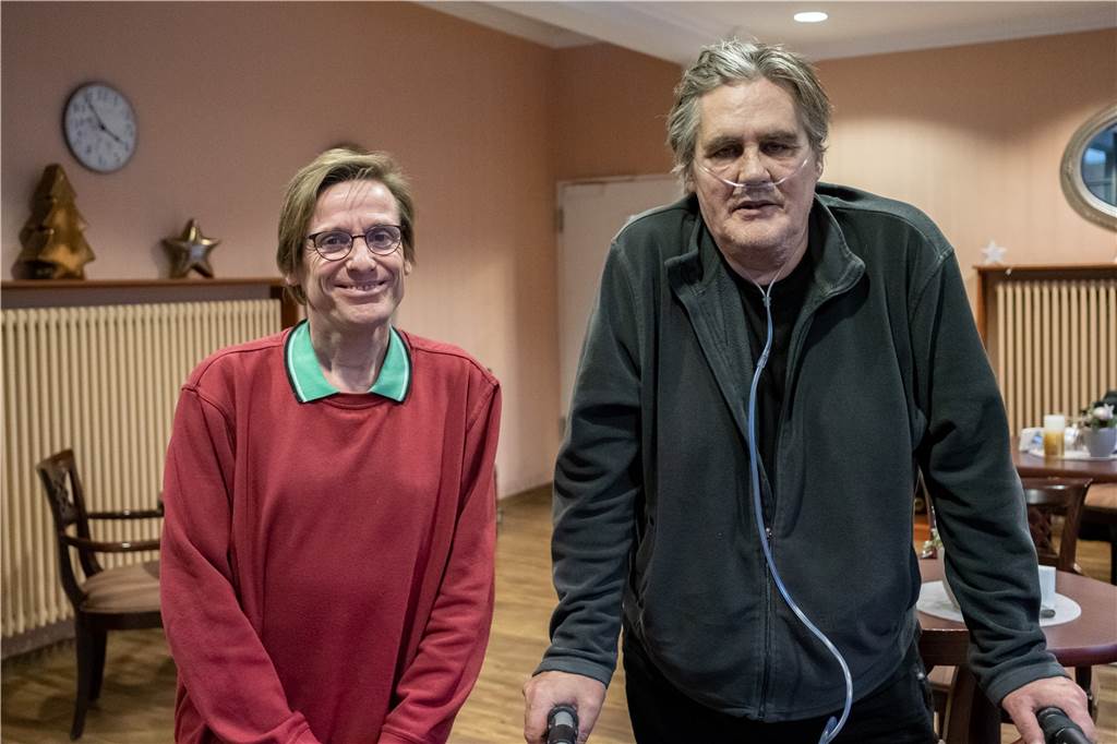 „Ich hab alles mitgenommen, was ging“ Rainer Mehlmann steht auf einen Rollator gestützt neben "Rainbow Visitor" Jochen Stoewer im Café des Wohnheims Zehnthof.