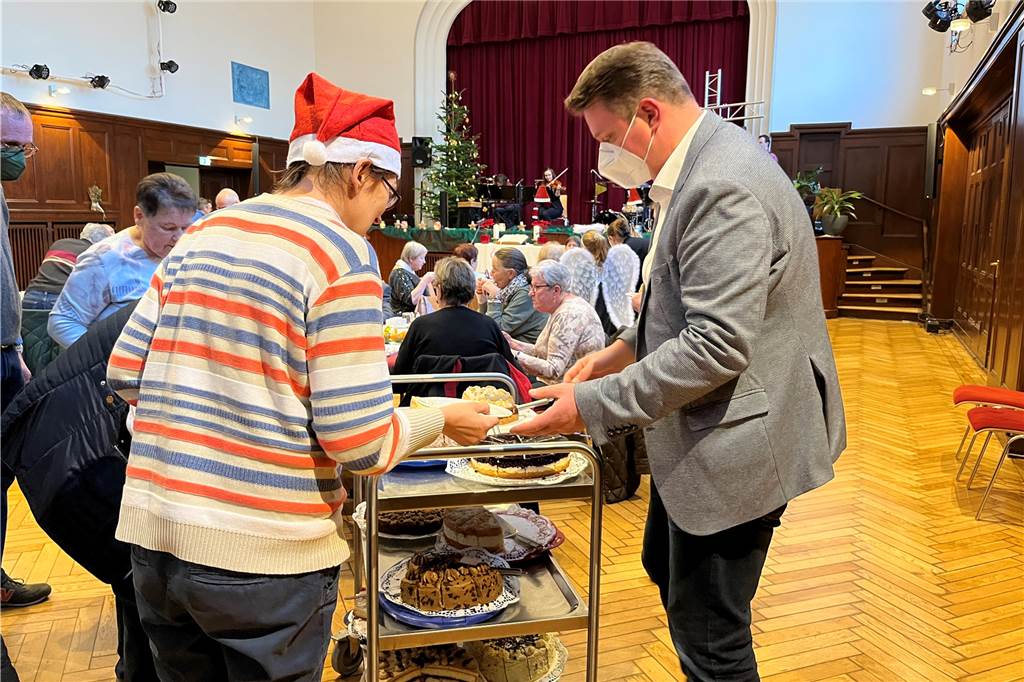 Bürgermeister Rajko Kravanja hilft Weihnachten 2022 im Wichernhaus in Castrop-Rauxel beim Kuchen austeilen.