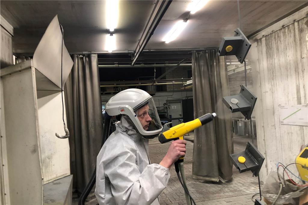 Vier-Tage-Woche: Firma will Energie sparen und attraktiver werden Ramon Garthaus beschichtet Metallteile mit der Sprühpistole.