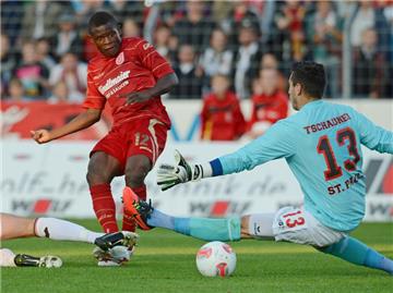 Regensburgs Francky Sembolo (l) erzielt gegen Pauli-Torwart Philipp Tschauner das 1:0. Foto: Armin Weigel