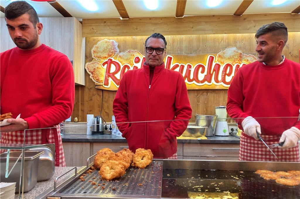Das sagen die Besucher des Weihnachtsmarkts zu den gestiegenen Preisen Randolf Schneider (M.) ist der Besitzer von Reibekuchen Schneider.