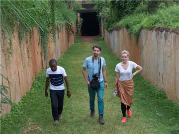 Reiseleiter Allan Kakembo (l-r) zeigt den finnischen Touristen Paavo Taimisto und Hanna Meinander im Buganda Palace in Kampala, Uganda, die Räume, in denen früher die Folterkammern des ugandischen Diktators Idi Amin untergebracht waren. Foto: Thilo Thielke