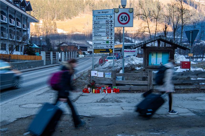 Reisende gehen an Blumen und Kerzen am Ort des Unfalls vorbei. Ein Auto war in eine Gruppe Urlauber gefahren und hat dabei sieben junge Deutsche getötet.