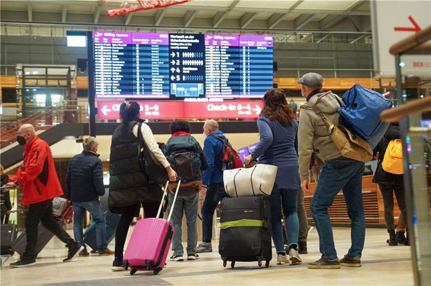 Etwa jedes zweite Land in der Welt derzeit Hochrisikogebiet Reisende stehen am Flughafen BER vor einer Info-Tafel.
