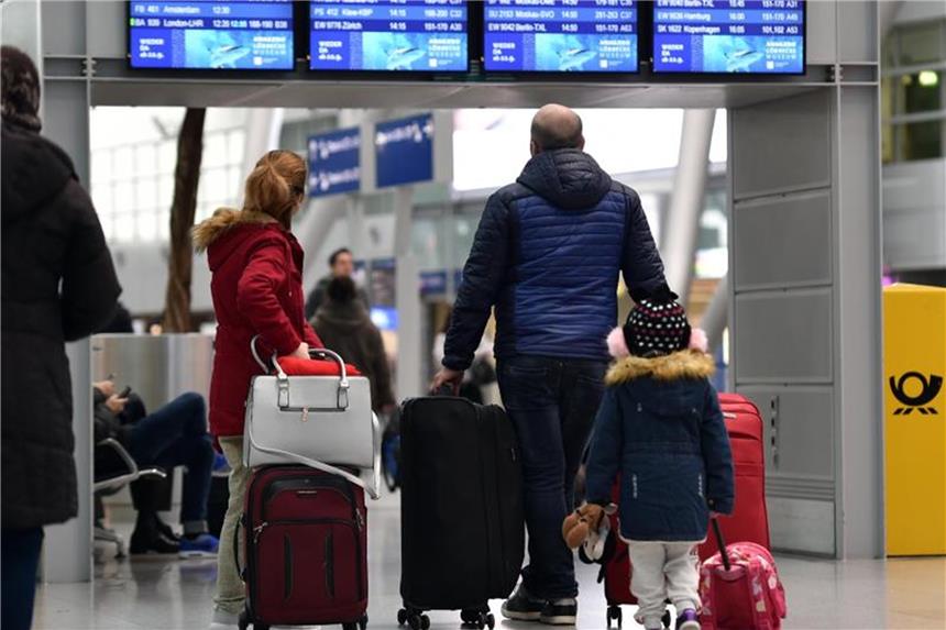 Flughafen Düsseldorf: Erste Reisewelle ohne großes Warten Reisende stehen im Flughafen Düsseldorf vor einer Abfluganzeigetafel. Foto: Caroline Seidel/Archiv
