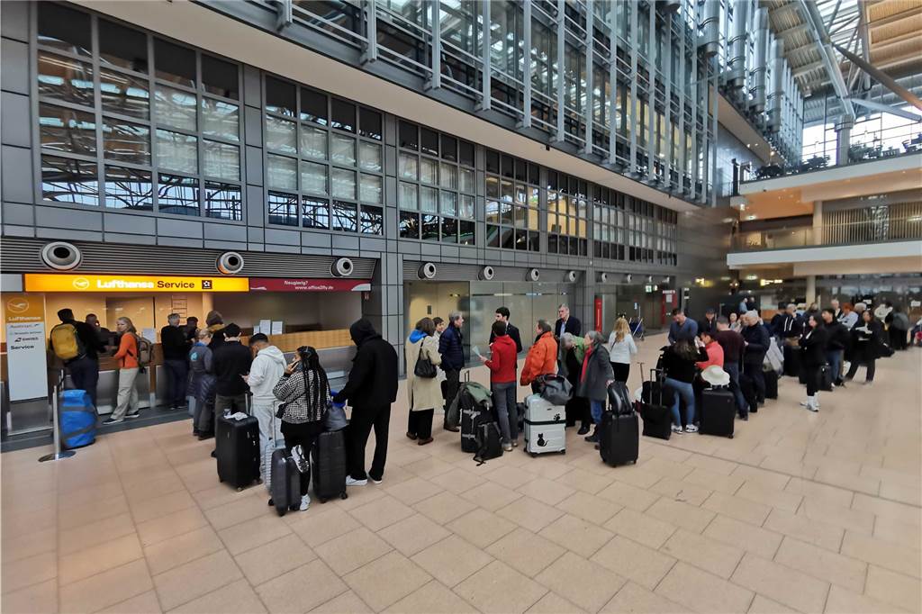 Reisende warten an einem Serviceschalter der Lufthansa. Eine IT-Panne sorgt für große Behinderungen bei der Lufthansa.