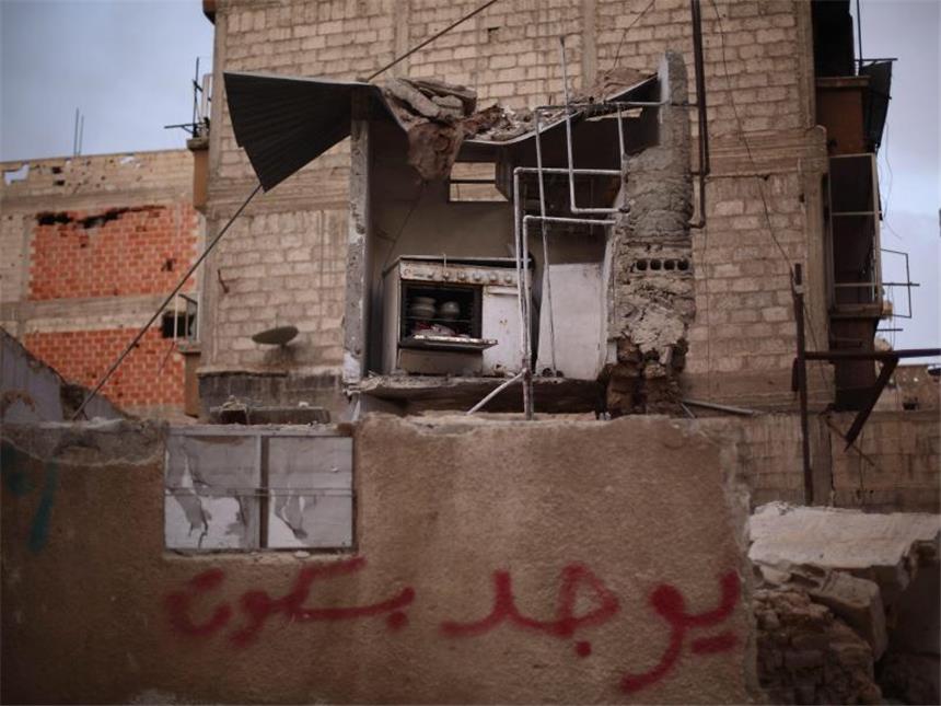 Syriens Opposition reist zu Friedensgesprächen Relikt aus Friedenszeiten: An der Mauer steht noch ein Hinweis auf frische Backwaren, dahinter nichts als Zerstörung. Foto: Mohammed Badra
