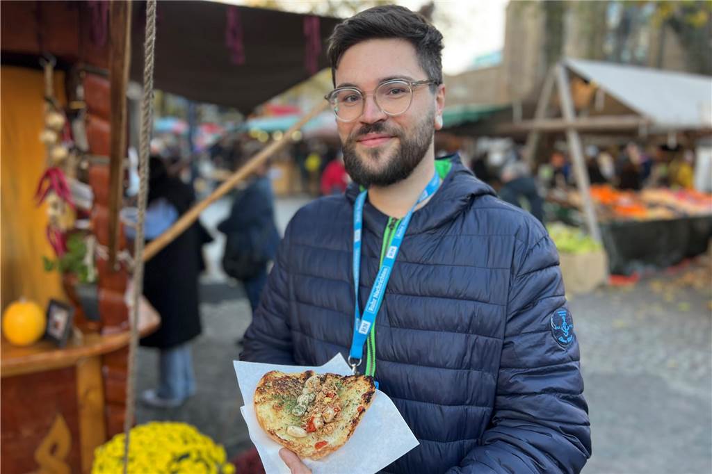 Kulinarische Highlights auf dem Hansemarkt: Fünf Gerichte im Test Reporter Nico Keßeboom mit dem veganen Knoblauchbrot von „Wanderpfanne" auf Dortmunds Hansemarkt.