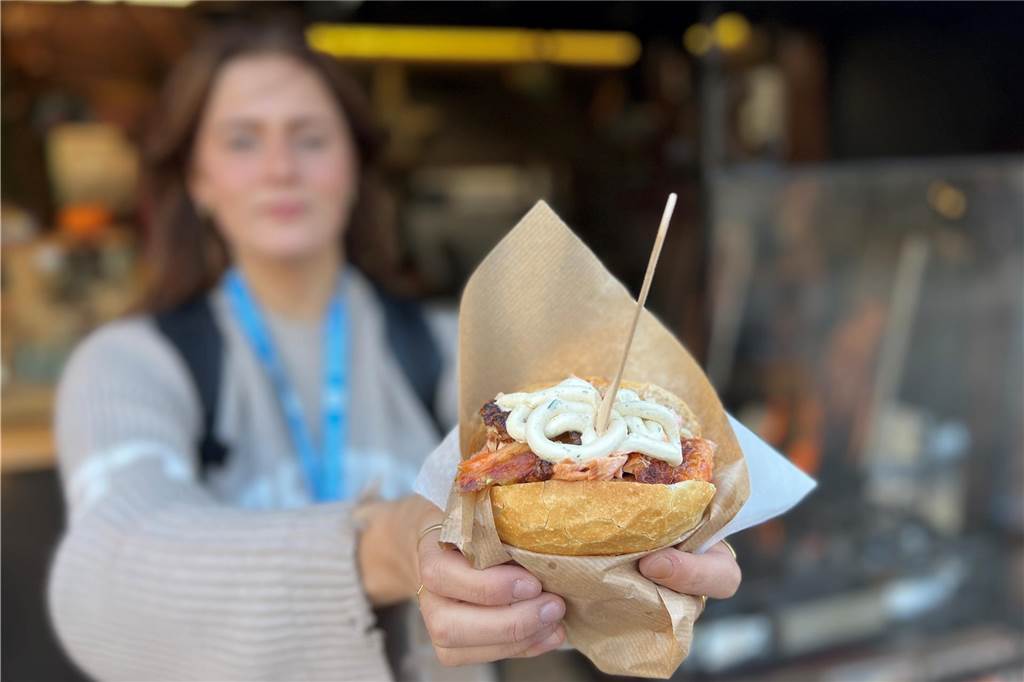 Kulinarische Highlights auf dem Hansemarkt: Fünf Gerichte im Test Reporterin Charlotte Schuster mit dem Flammlachs-Brötchen von „Lachs Wikinger" auf Dortmunds Hansemarkt.