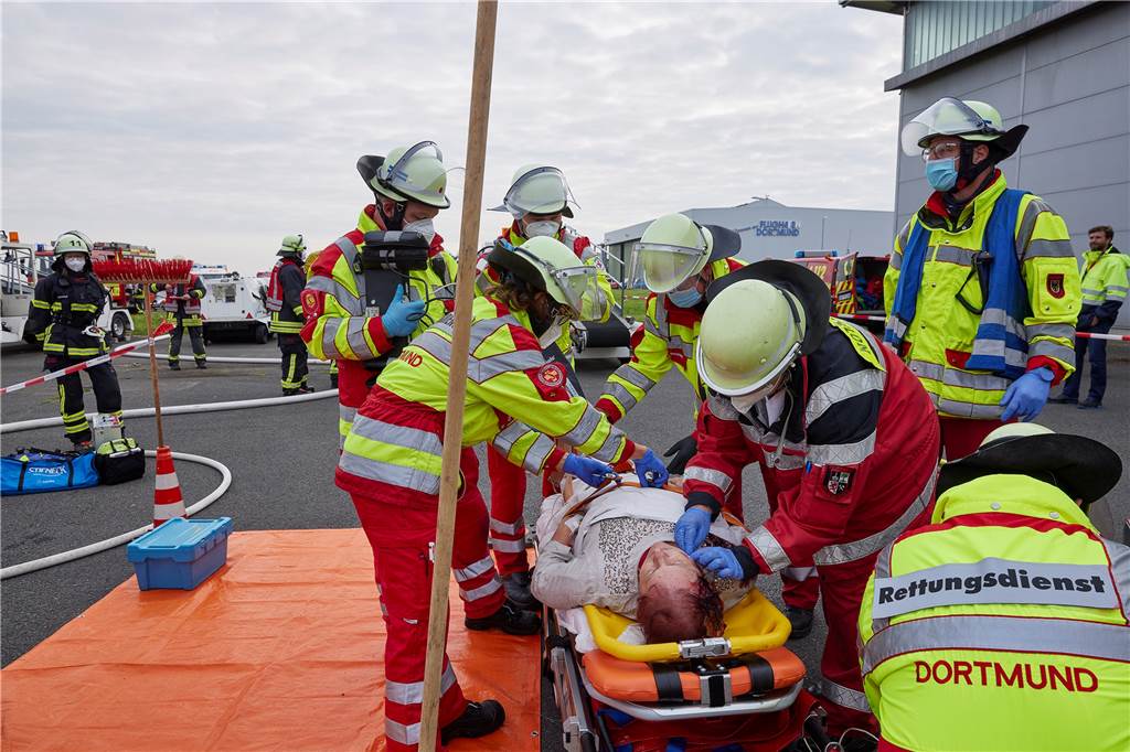 Unfalldarstellerin mit Platzwunde aus Kunstblut wird von Rettungskräften versorgt.