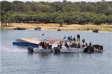 Rettungskräfte sind am Unglücksort neben der gekenterten Fähre im Einsatz. Foto: XinHua