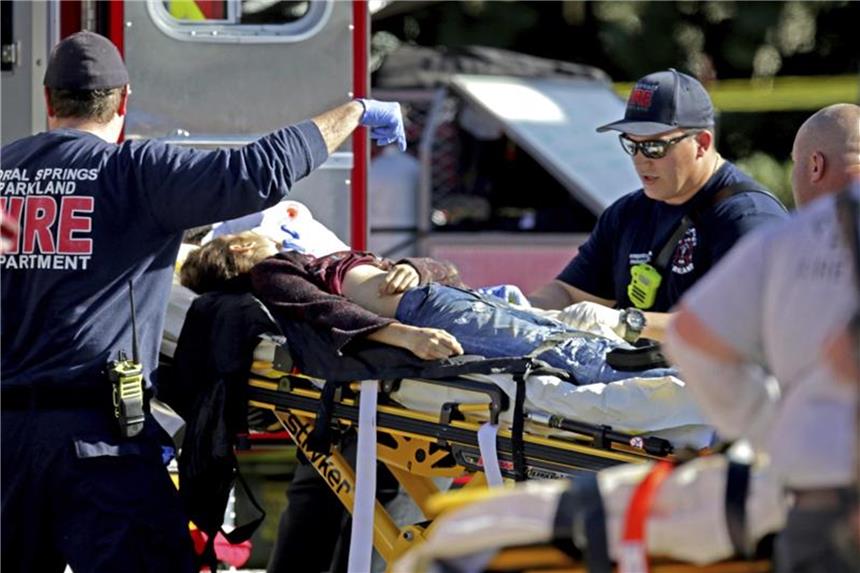 Rettungskräfte versorgen ein Opfer, nachdem an der Marjory Stoneman Douglas High School in Florida Schüsse gefallen sind. Foto: John Mccall/South Florida Sun-Sentinel/AP/Archiv
