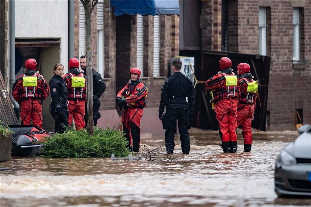 Unwetter in NRW: Mindestens 43 Todesopfer - mehrere Plünderungsversuche gemeldet – Liveblog Rettungsschwimmer und Polizeitaucher stehen in einer überfluteten Straße im Ortsteil Blessem.