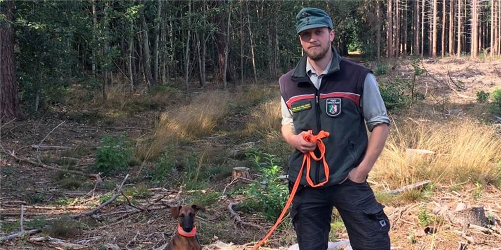 Es wird heiß: Wie hoch ist die Waldbrandgefahr für Dorsten, Lennart Besten? Revierförster Lennart Besten steht im Wald mit seinem Hund.