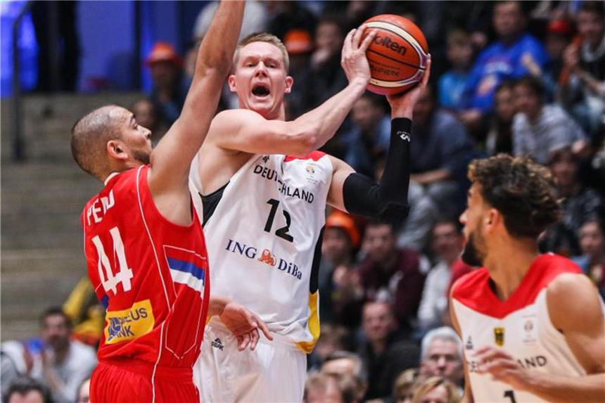 Deutsche Basketballer besiegen überraschend Serbien Robin Benzing (M) spielt am Serben Stefan Peno (l) vorbei den Ball zu seinem Teamkameraden Joshiko Saibou. Foto: Frank Rumpenhorst