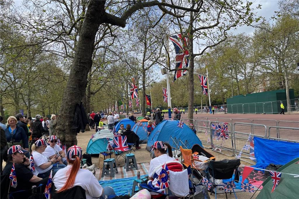 Krönung von Charles III. in London: Gästeliste, Ablauf, Programm Royals-Fans tragen Ponchos und warten bei Regen auf der Mall, einem Teil der Krönungsroute.