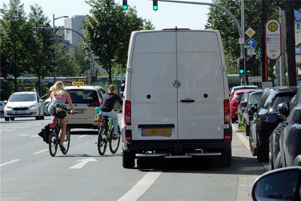 Jeder gegen jeden - hier kommen sich Radfahrer, Autofahrer und Fußgänger in die Quere Rücksichtnahme? Fehlanzeige! Der Lieferwagen hält auf dem Radweg, die Radlerinnen flitzen nebeneinander drumherum - ohne Helm.