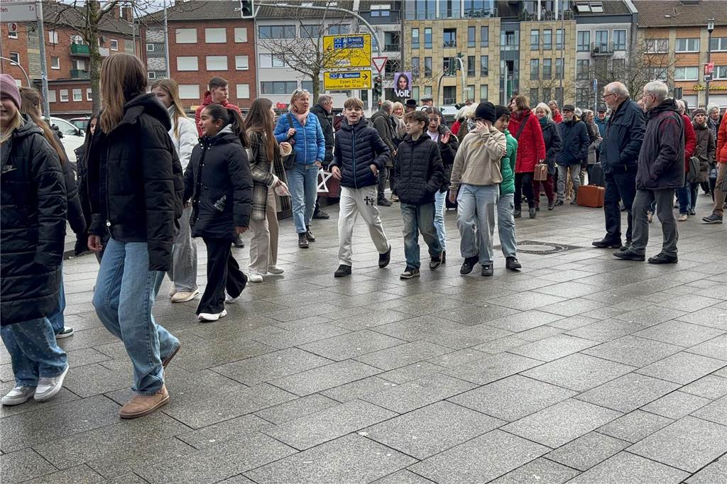 Einige Menschen stehen auf dem Goldenen Anker. Im Vordergrund sind Schüler zusehen. 