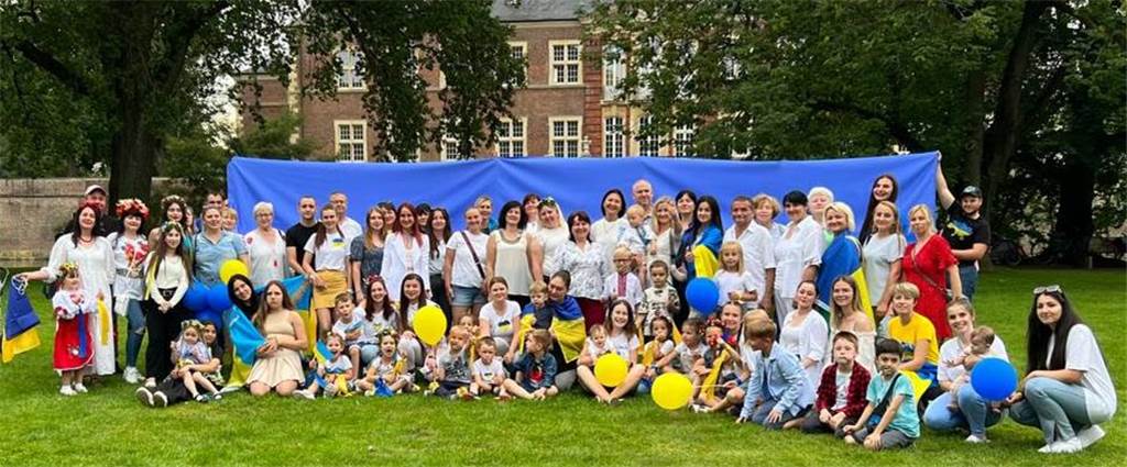 Flüchtlinge: Ukrainischer Unabhängigkeitstag und wenig Platz in Unterkünften Die Teilnehmer vor einer großen ukrainischen Flagge