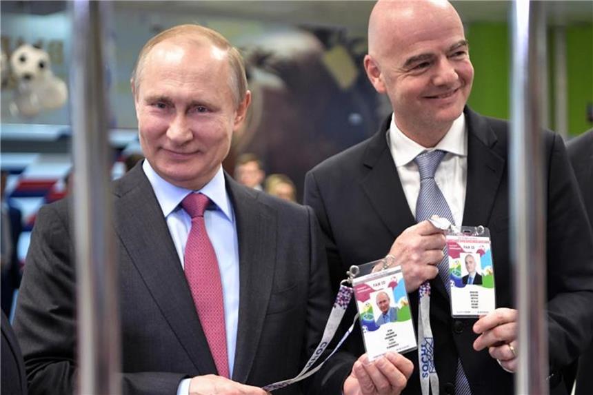 Russisches Parlament will Fan-ID als Visum verlängern Russlands Präsident Wladimir Putin (l) und FIFA-Präsident Gianni Infantino zeigen beim Betreten eines Stadions ihre Fan-ID. Foto: Alexei Nikolsky/POOL SPUTNIK KREMLIN/AP