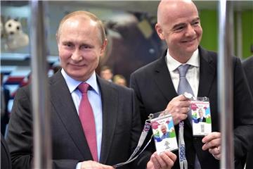 Russlands Präsident Wladimir Putin (l) und FIFA-Präsident Gianni Infantino zeigen beim Betreten eines Stadions ihre Fan-ID. Foto: Alexei Nikolsky/POOL SPUTNIK KREMLIN/AP